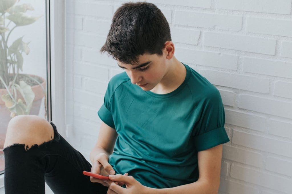 Teen boy uses social media and is less connected with others.