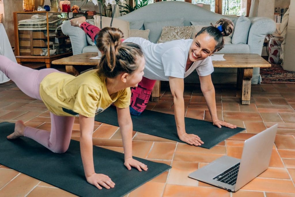 Mother who sets healthy boundaries enjoys yoga with teenager.