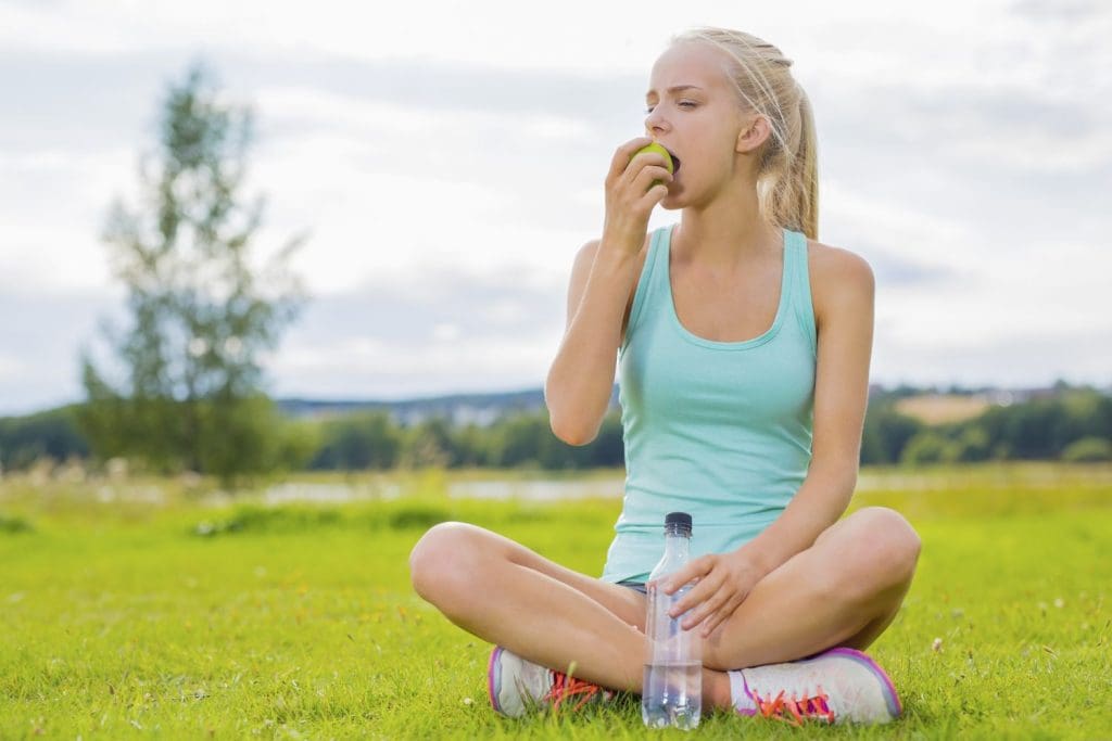 Teen eats apple to improve gut health and mental health.