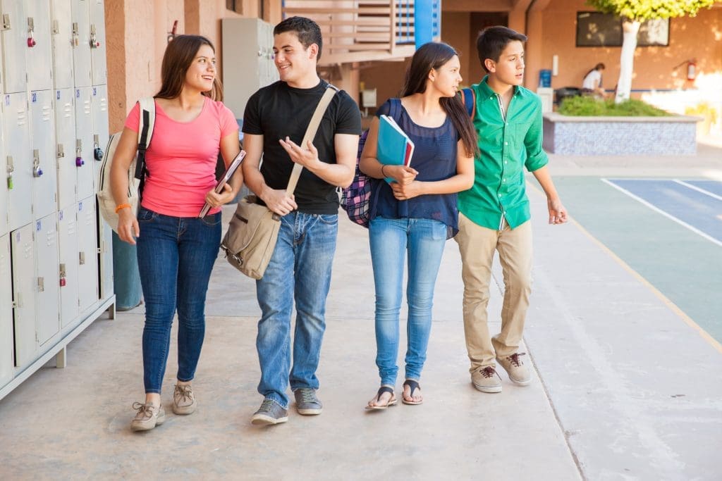 Teens walk to class while reassuring each other about fear of school.