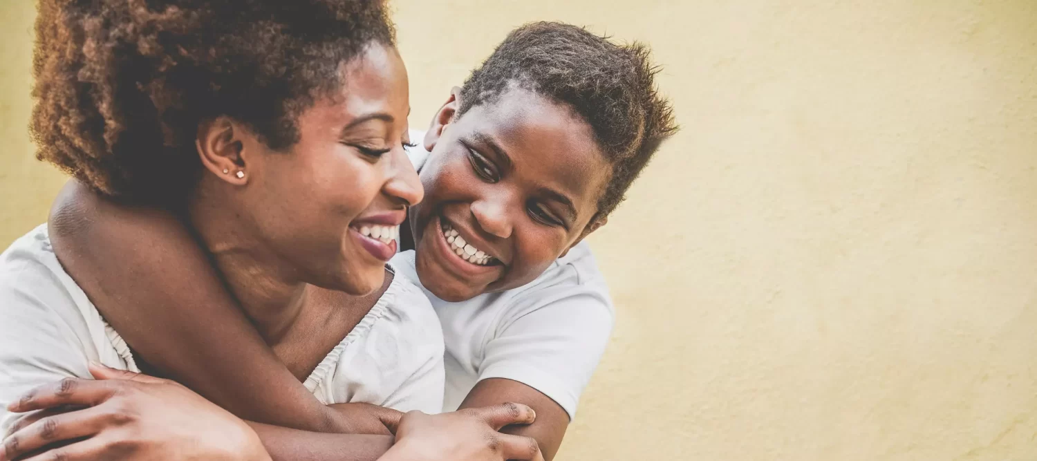 Mother and adolescent son smiling after talking about receiving mental health treatment at Embark Behavioral Health.