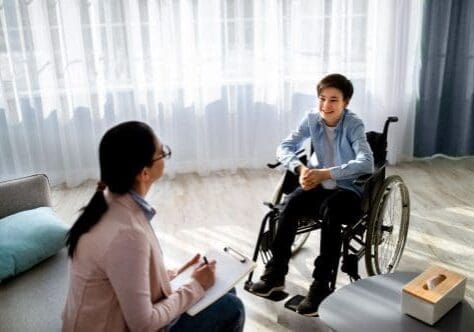 Teenager speaking with therapist during therapy session in outpatient program.